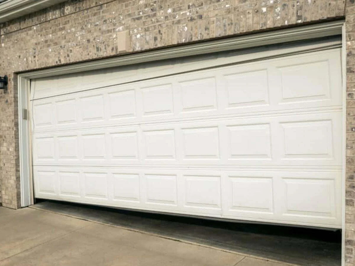 Technician explaining garage door repair upgrades to homeowner while tools and materials are prepared for a quieter, safer system.